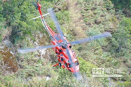 失聯2日的巨陞公司董座陳宏育及妻子范錦美,被發現摔落台8線中橫公路159.1公里處,消防人員以空勤將兩人遺體吊掛下山。(張祈攝)