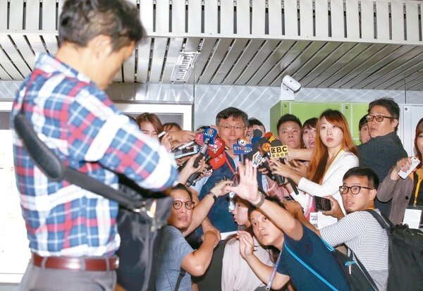 台灣國辦公室主任陳峻涵（左）昨朝台北市長柯文哲丟拖鞋，並高喊「柯文哲，不要做中共同路人」。柯文哲稍後迅速蹲下，消失在麥克風堆中。 記者高彬原／攝影