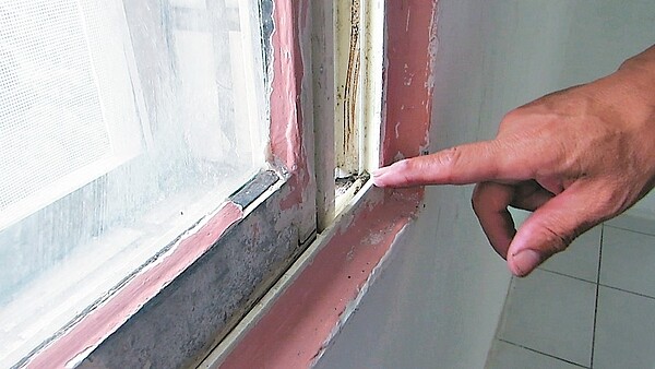 詹姓屋主指張姓前房客為防蟻將矽氧樹脂及補土填抹窗戶漆。 記者范榮達/攝影
