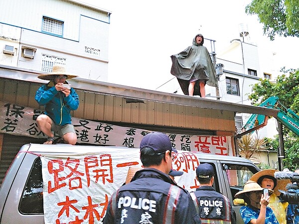 台南市政府執行西港外環道開闢案地上物拆除作業，自救會成員爬上屋頂阻絕拆除進行。 記者謝進盛／攝影