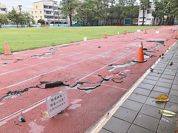 高雄彌陀國小的PU跑道嚴重破損、隆起甚至剝離，校方擺上角椎警示。 圖／彌陀國小提供