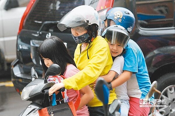 臨時宣布放假,家長們趁著風雨不大之際趕緊來接孩童回家。(黃世麒攝)