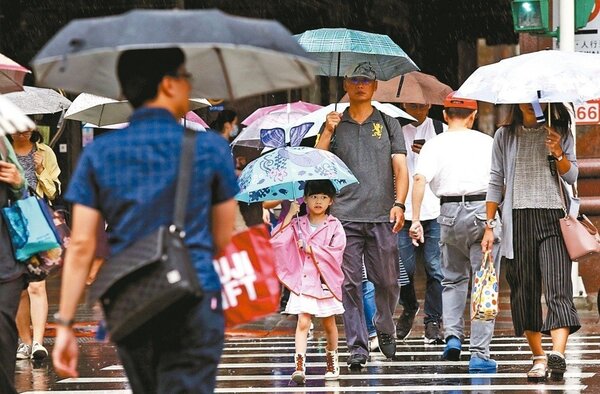 雙北颱風假不同調，台北市民眾昨在風雨中趕上班，幼兒在家長陪同下冒雨上學。 記者林俊良／攝影