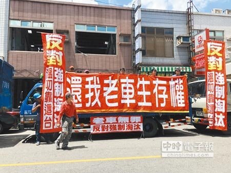 環保署要全面淘汰10年以上老舊車,引起大貨車業者不滿,在車身掛抗議布條。 (許素惠攝)