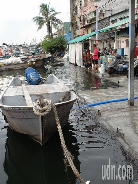 高雄旗津不少居民人趁著大潮來,就站在岸邊,腳浸在海水裡釣魚,根本分不清海面或路面。記者謝梅芬/攝影