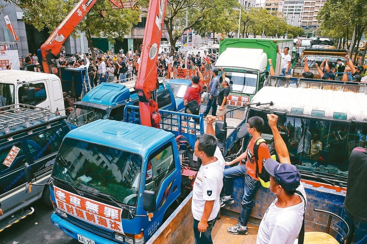 全國老汽機貨車自救會上午南北大動員，多台貨車、卡車與舊型機車汽車聚集環保署，抗議空汙法中不利老車的相關條文，抗議民眾高舉標語表達不滿。 記者鄭清元／攝影