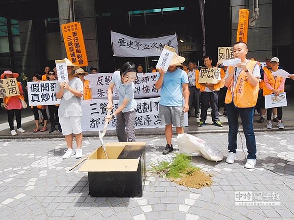 三峽龍埔里自救會19日在新北市府前演出行動短劇,諷刺市府強徵農地,還黑箱作業不通知地主開會。(吳岳修攝)