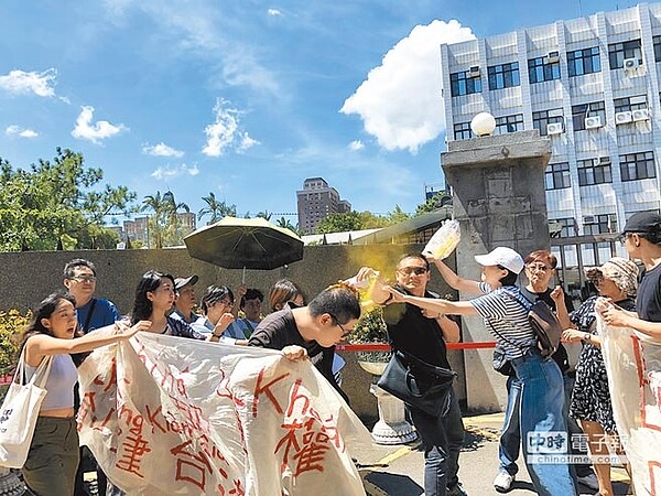 228慈湖潑漆案20日首度開庭審理,涉案青年在桃園地院前說明訴求時,遭噴黃漆。(蔡依珍攝)