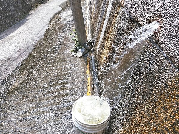 基隆市劉銘傳路一處擋土牆漏自來水3年多，馬路都變成水溝。 記者游明煌／攝影