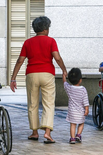 行政院通過「我國少子化對策計畫」,補助新制明天上路,圖為阿嬤牽著孫子散步。 記者鄭清元/攝影