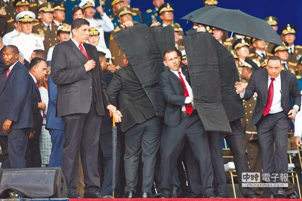 委內瑞拉總統馬杜羅遭到無人機炸彈襲擊，安全人員緊急上前保護，馬杜羅安然無恙。（新華社）