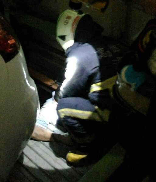 胡姓計程車司機不小心掉落機械停車位下層,經消防人員救起。記者黃宣翰/翻攝