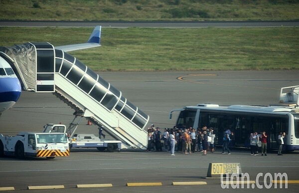 桃園機場接駁機坪運作對旅客不便，上下飛機晴天曬太陽沒有冷氣服務，雨天淋雨的機會很高。圖為桃園機場接駁機坪旅客從接駁車下來，準備爬樓梯登機情形。 記者陳嘉寧／攝影