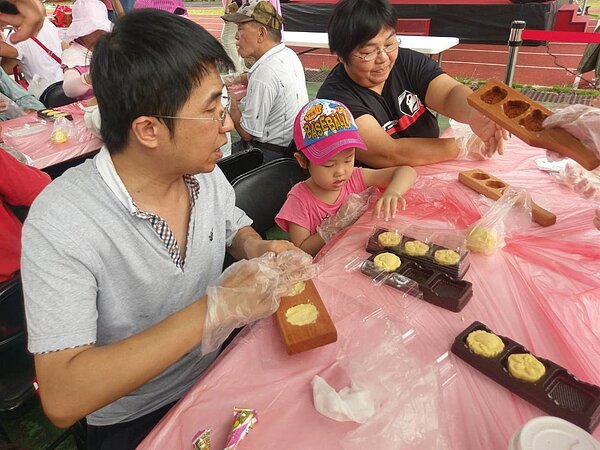 新竹縣政府昨天在內灣國小舉辦「台三線國民美食推廣計畫」成果展,民眾正在體驗DIY古早味綠豆糕。圖/新竹縣政府提供