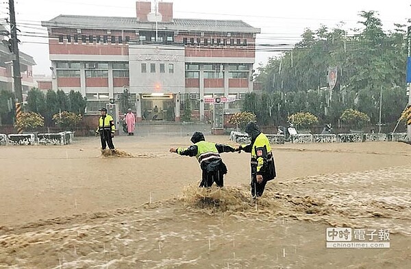 員林市14日下午又因強降雨造成淹水災情，在東山派出所前，員警冒雨指揮交通，也身陷危險中。（鐘武達翻攝）