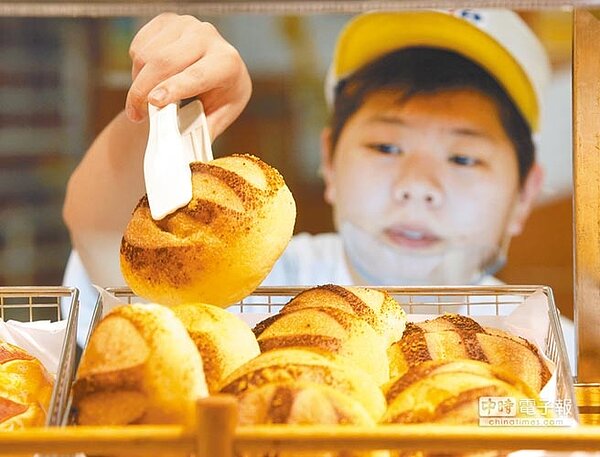 基本工資將調漲5%,全國工業總會代表何語不諱言,店家勢必將成本轉嫁到消費者身上。圖為麵包店員工忙著將麵包上架。(本報資料照片)