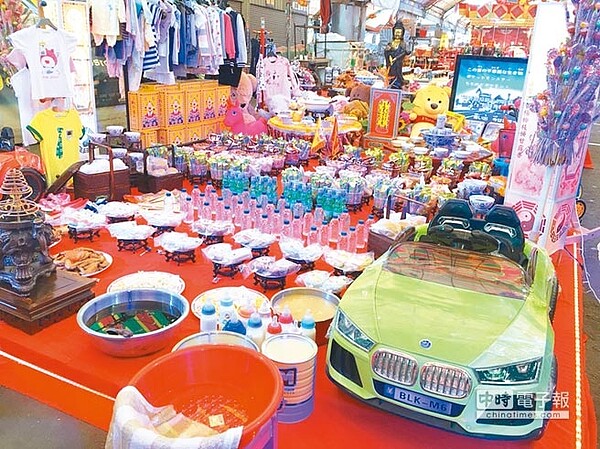 台中市環保市集17日中元普渡,為安慰來不及長大的孩子,特別設置「囝仔普」,供奉糖果餅乾、玩具還有電視,要讓小鬼們可以看卡通。(馮惠宜攝)