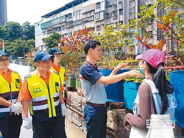 汐止區長徐開宇示範清理室外積水容器。(宋原彰翻攝)