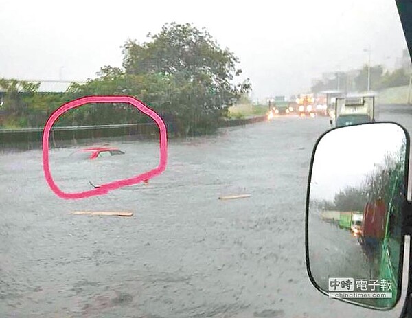 前鎮草衙路與金福路的大貨車專用道淹水,近中午有輛紅色自小客車誤闖慘遭滅頂,幸好溫姓女駕駛自行脫困。(柯宗緯翻攝)