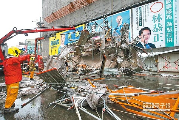 高雄市建國路、自立路口1棟大樓的12樓鷹架，23日因強風吹襲坍塌，壓住路過2輛機車共3個人，3人救出時都無生命跡象，最後只有戴姓女子被救活但尚未脫險。（王錦河攝）
