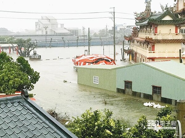 24日上午雨勢不斷，造成麻豆北勢地區道路變成一片汪洋，房屋和車子也泡在水中。（李其樺翻攝）
