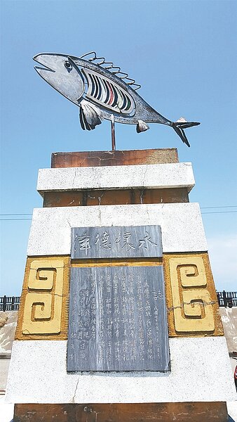 苗栗縣通霄鎮新埔國小的公共藝術作品「彩虹魚」,用蔣公銅像基座設置,保有「永懷德澤」碑文。 記者胡蓬生/攝影