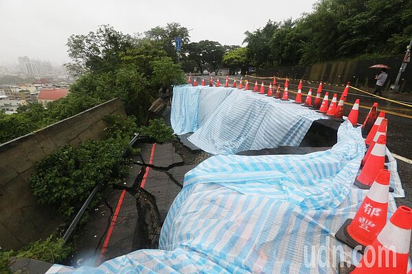 高雄今天一整天下起豪雨,各地區災情不斷。距離壽山動物園約150公尺、興隆路上的萬壽山橋受不了大水沖刷,現場塌陷20公尺以上,隨時都有崩塌危機,工務單位已經派員搶救。(圖/記者劉學聖攝影)