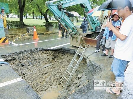 也是豪雨釀災!台南市東區長榮路一段、二段路面28日出現3處下陷,警方趕緊拉起封鎖線,並當場開挖查明原因。(曹婷婷攝)