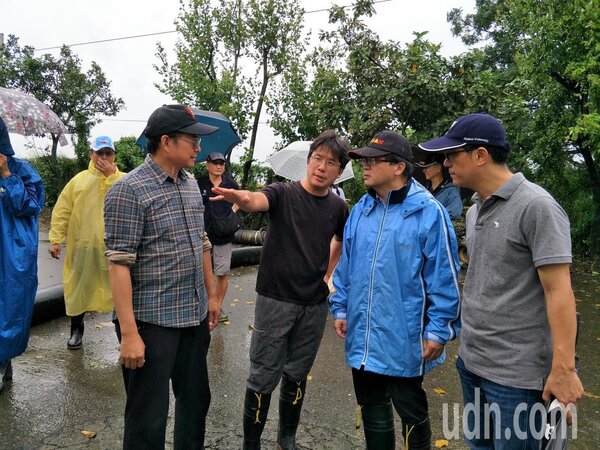 台南市代理市長李孟諺（右二）勘查積水區域，聽取校方人員說明積水情形。（圖／記者謝進盛攝影）