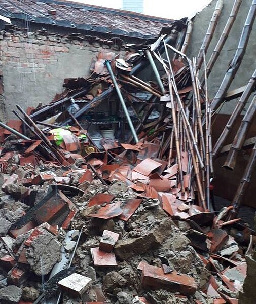 古厝屋頂坍陷,磚瓦掉落一地。(圖/記者王昭月攝影)