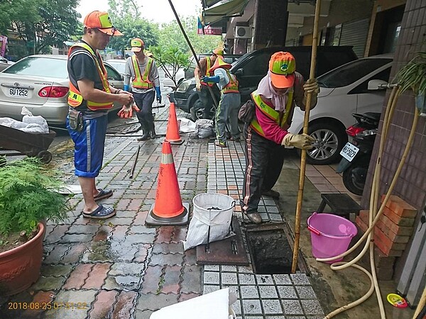 連續多日豪雨讓高雄市容滿目瘡痍，市府將招募232名臨時工作名額，投入災後復原工作。圖為環保局清潔隊員清疏水溝。圖／高雄市環保局提供