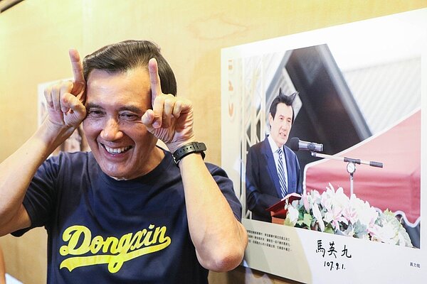 前總統馬英九看完自己頭髮高飛的照片，用雙手比牛角手勢賣萌。（圖／記者王敏旭攝影）