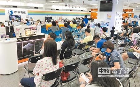 民眾12日趁著周末假日搶辦電信業者499吃到飽方案，雖然排隊情況稍緩，但民眾依舊在櫃台前花了不少時間等待。（姚志平攝）