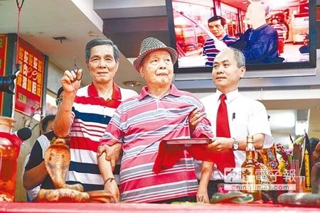 亞洲毒蛇研究所21日正式熄燈，最後一代弄蛇人洪丁福（左）與郭家兩代老闆郭來貢（中）一同為殺蛇剪封刀。（鄧博仁攝）