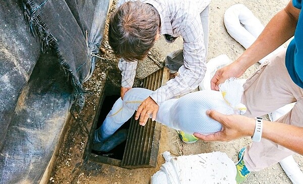 典寶溪上游遭人偷倒廢油,所幸油汙都還卡在水溝內未外流,環保局已加設攔油索和吸油棉。 圖/高雄市環保局提供
