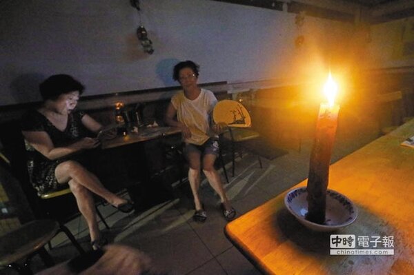 去年全台17縣市大停電，店家點起蠟燭照明。（本報資料照片）