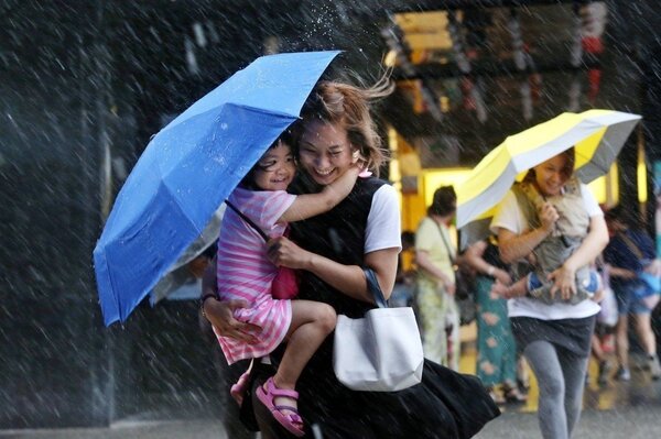 鋒面來襲，北台灣高溫較前兩天下滑近十度，傘下的民眾帶著笑容，期待下雨降溫，也稍解水荒壓力。圖／聯合報系資料照片