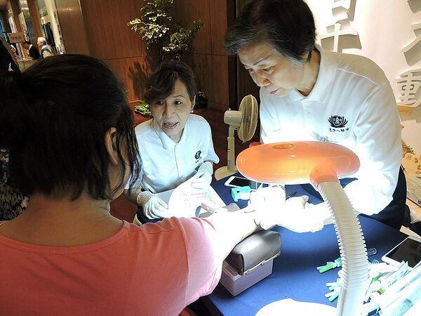 吳伊伶(右)「捐髓救人、無損己身」,現已經是兩個孩子的媽,媽媽游玉珍(左)常陪同她參與驗血建檔活動的分享。(慈濟基金會)