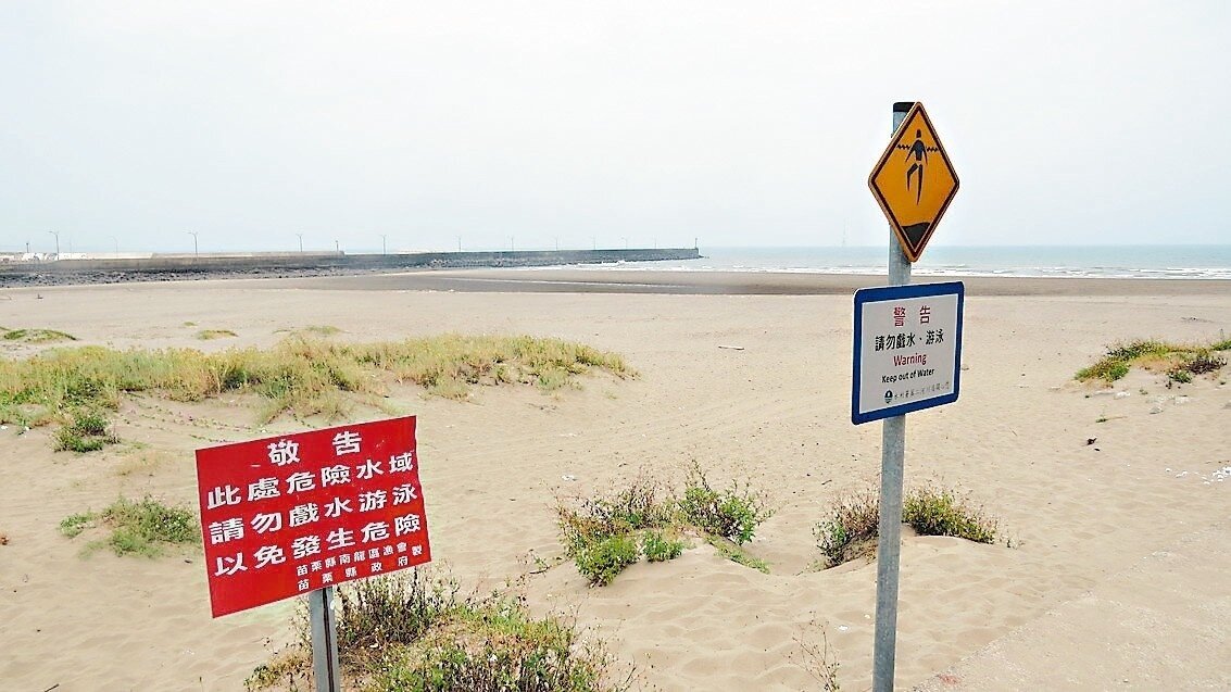 苗栗縣竹南鎮龍鳳漁港沿岸豎立警告危險水域的告示,但不少民眾視若無睹。 記者范榮達/攝影