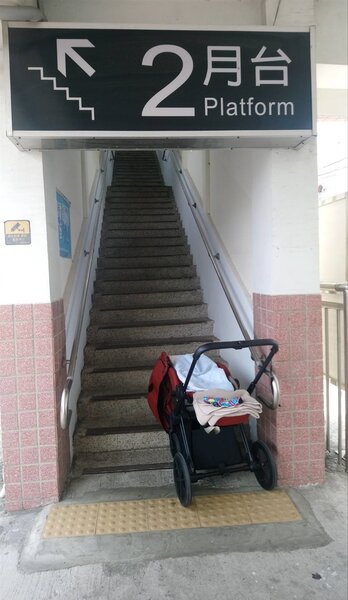 嘉義縣水上火車站通往南下第二月台，只能走天橋，推娃娃車的母親只能先抱小孩爬樓梯，再請人幫忙搬娃娃車。 記者卜敏正／攝影
