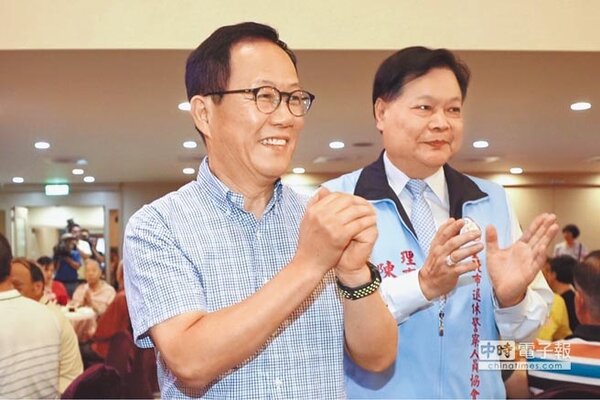 國民黨台北市長參選人丁守中（左）出席國軍英雄館的「台北市退休警察人員協會慶生會」，拱手向與會人員致意。（中央社）