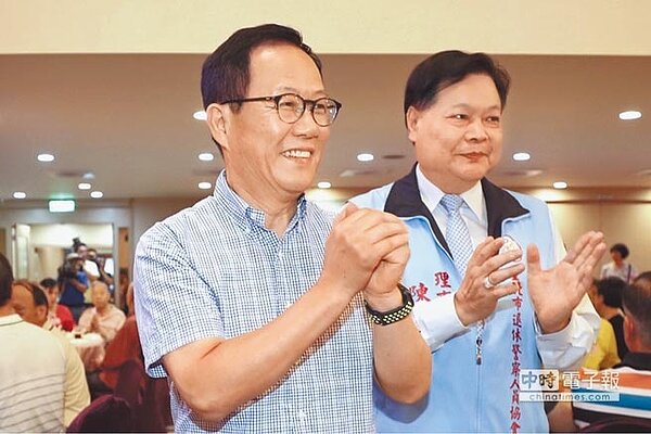 國民黨台北市長參選人丁守中（左）出席國軍英雄館的「台北市退休警察人員協會慶生會」，拱手向與會人員致意。（中央社）