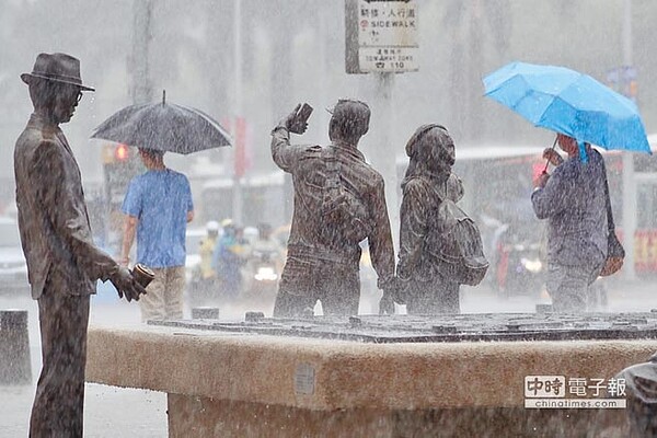 中央氣象局表示,受低壓帶影響,13至16日西南風增強並持續帶來南方水氣,應慎防局部大雨。台北市10日下午降下大雨,街頭民眾撐傘擋雨。(中央社)