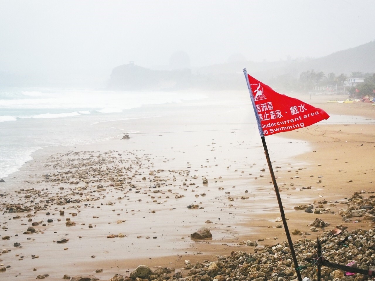 屏東墾丁昨天烏雲蔽日，海岸掀起逾2公尺長浪，岸邊均插上禁止下水的紅旗。 記者潘欣中／攝影