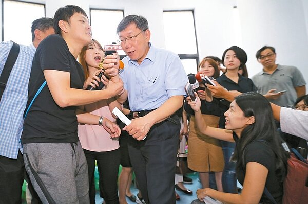 台北市長柯文哲（中）昨天參加民政局績優鄰里長頒獎，活動前他接受媒體記者訪問，最後在幕僚協助下才脫身。 記者許正宏／攝影