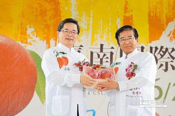 台南市代理市長李孟諺(左)贈送芒果給來參加開幕典禮的日本靜岡縣富士宮市市長藤秀忠,彰顯友好情誼。(李其樺翻攝)