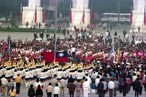 1990年在中正紀念堂舉行升旗活動,民眾肅立齊唱國歌。 圖/聯合報系資料照片