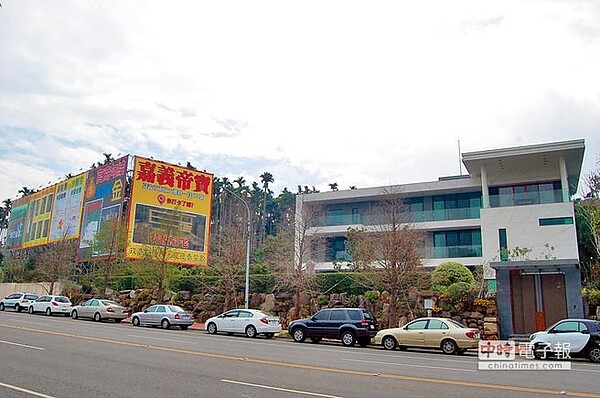 蘭潭保護區畔的白色豪宅旁遭掛大型看板喻為「嘉義帝寶」,爆料招待政商名流。(廖素慧攝)