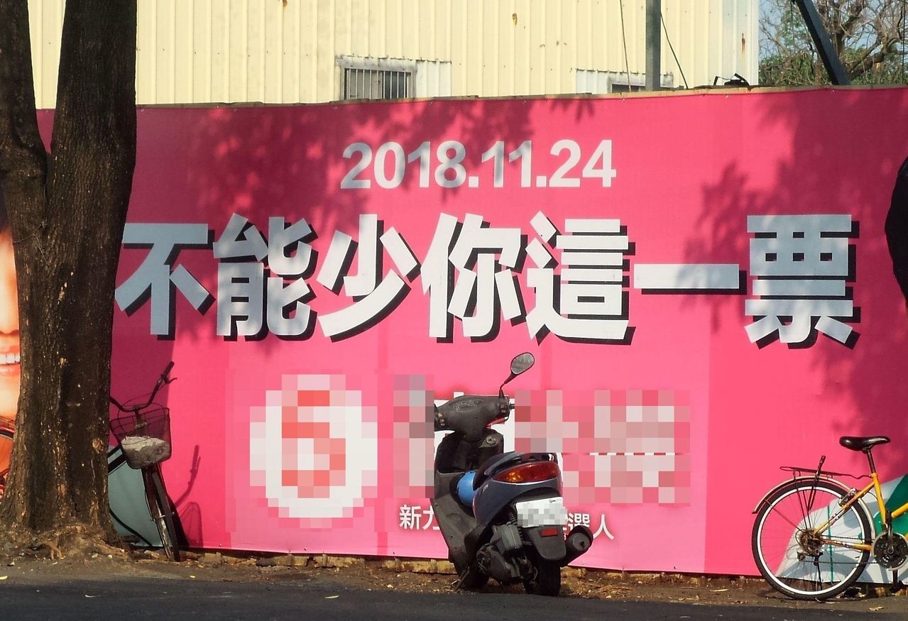 高雄市議員候選人設在岡山區一處彎道的看板文字，令人乍看吃驚。記者林保光／攝影