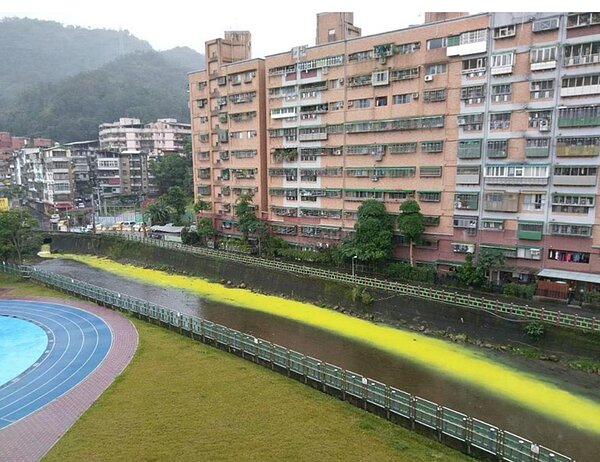 青潭溪因被倒入油漆,導致變成螢光河。圖/王姓居民提供